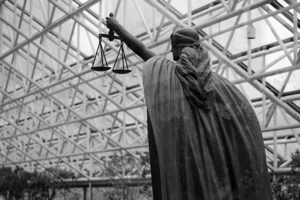 Statue de la dame justice tenant des balances à l’intérieur, par Albert Stoynov (@albertstoynov), licence Unsplash